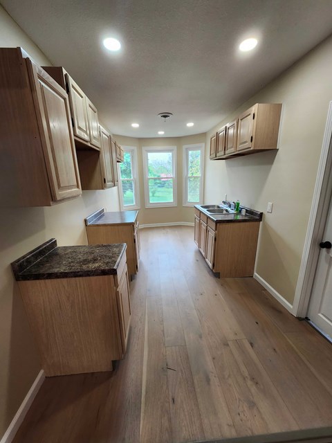 A kitchen with wooden cabinets and a marble countertop.