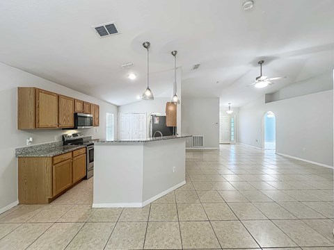 A kitchen with wooden cabinets and a granite countertop.
