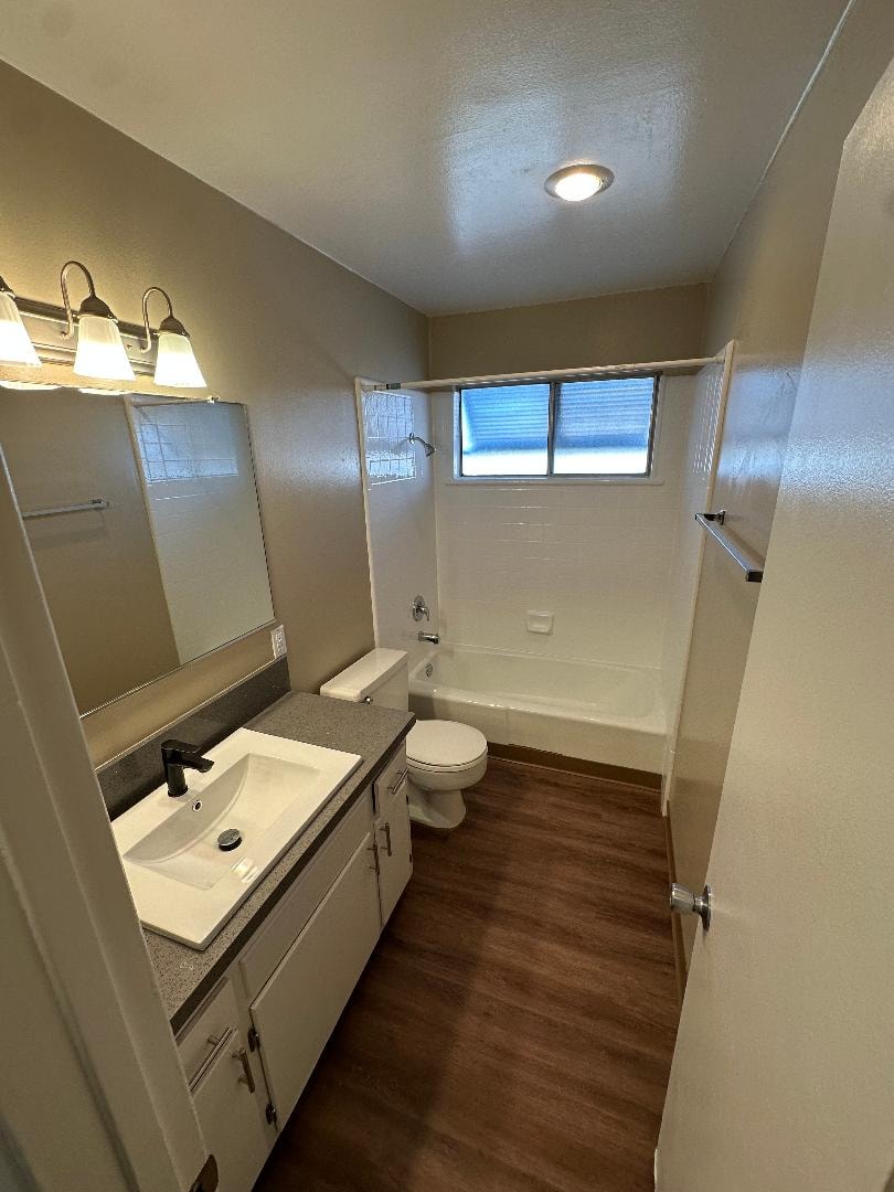 A bathroom with a toilet, sink, and mirror.