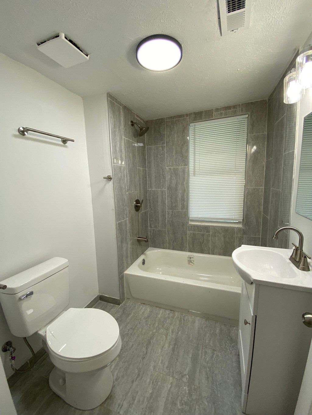 A white toilet sits next to a white sink in a bathroom.