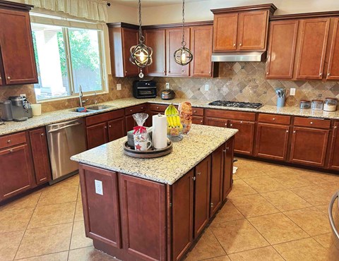 A kitchen with brown cabinets and a granite countertop.