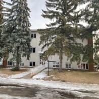 A white building with a brown fence in front of it.
