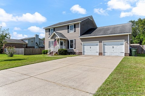 A two-story house with a garage and a flag on the front.