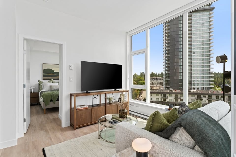 A modern living room with a large window overlooking a cityscape.