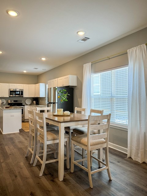 A dining room with a table set for four.