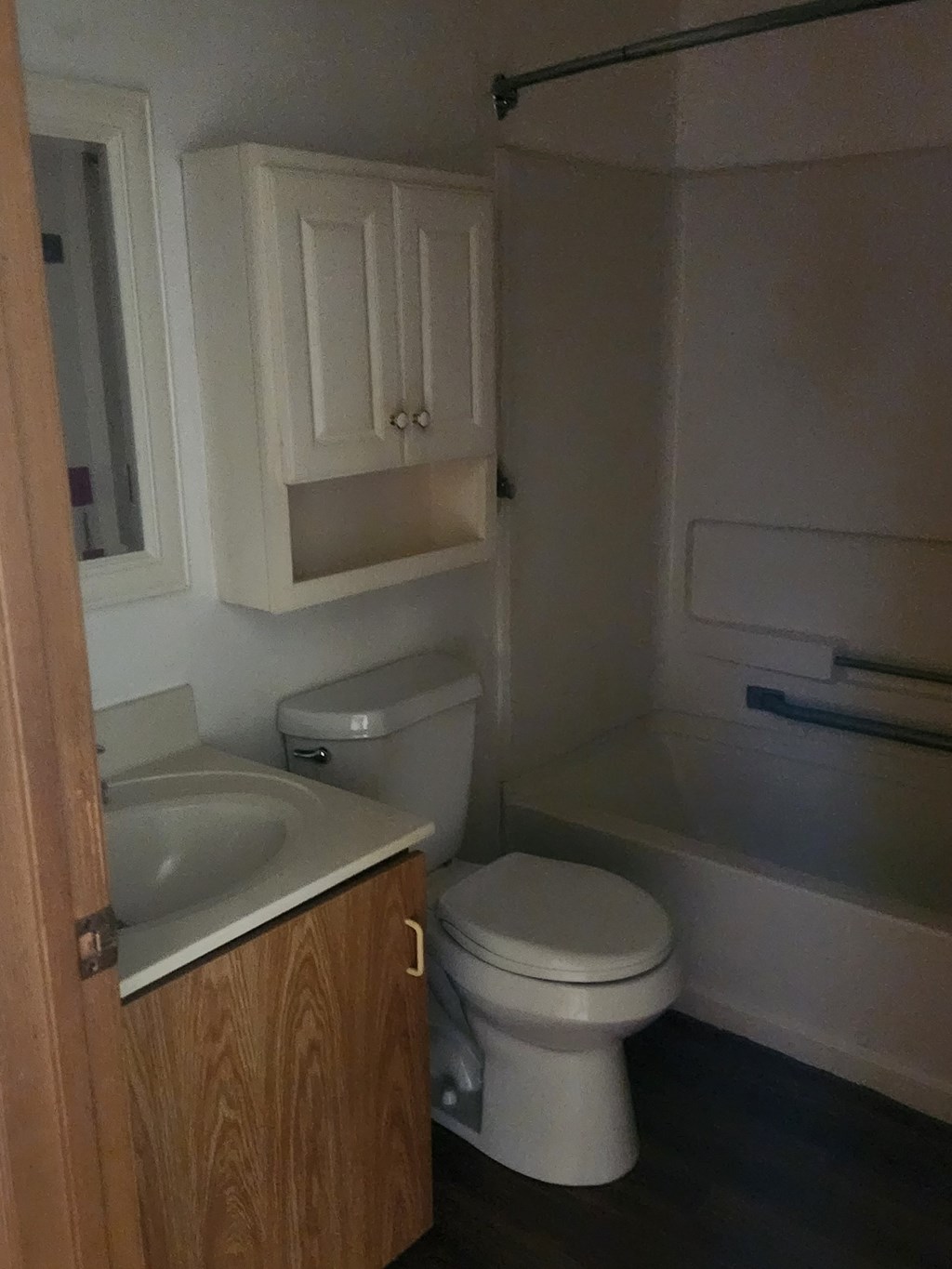 A white toilet sits next to a sink in a small bathroom.