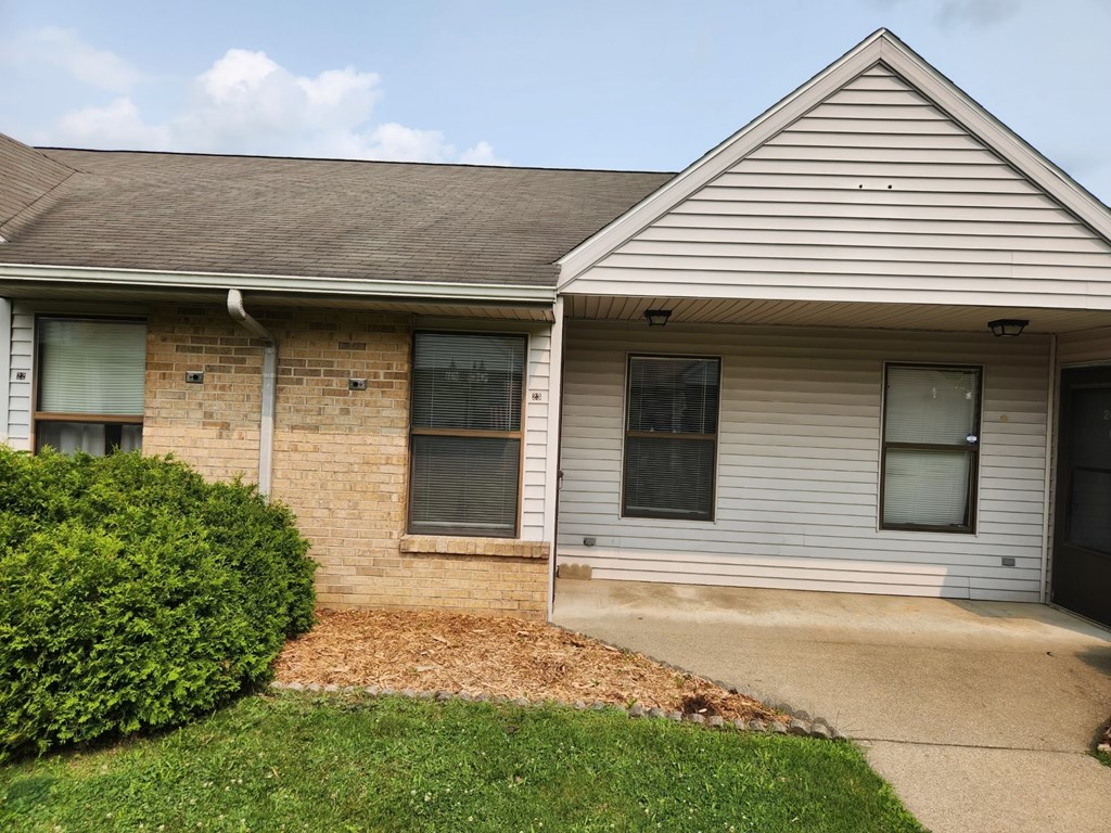 A house with a grey roof and a brown brick wall.