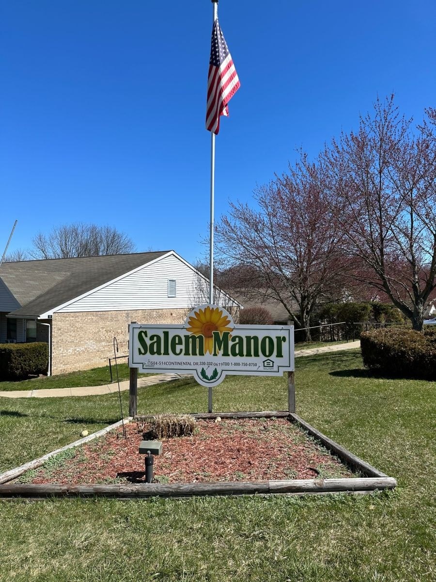 A sign that says Salem Manor in front of a house.