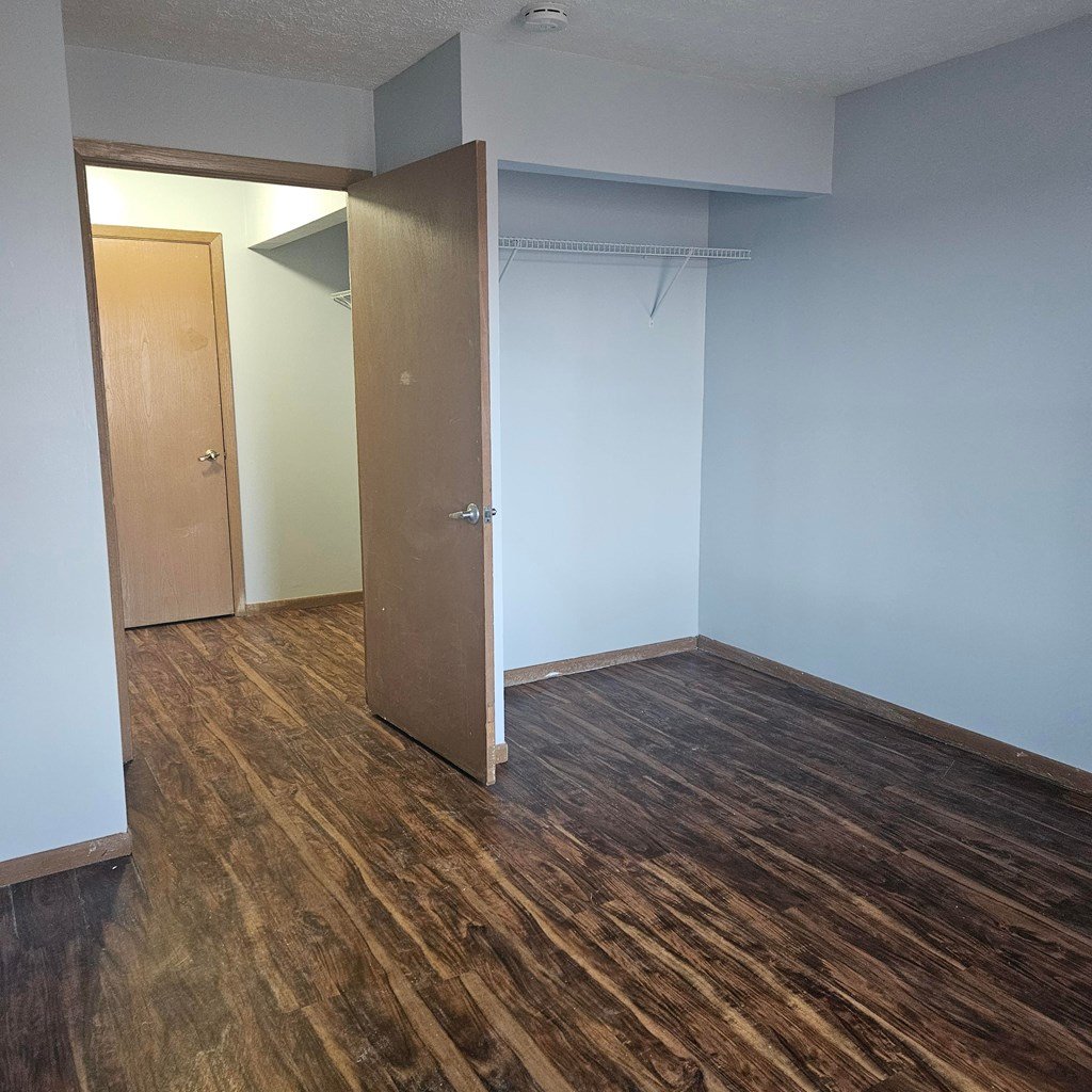 A room with a wooden floor and a white wall.