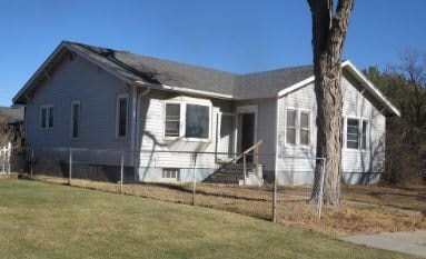 A house with a white siding and a grey roof.