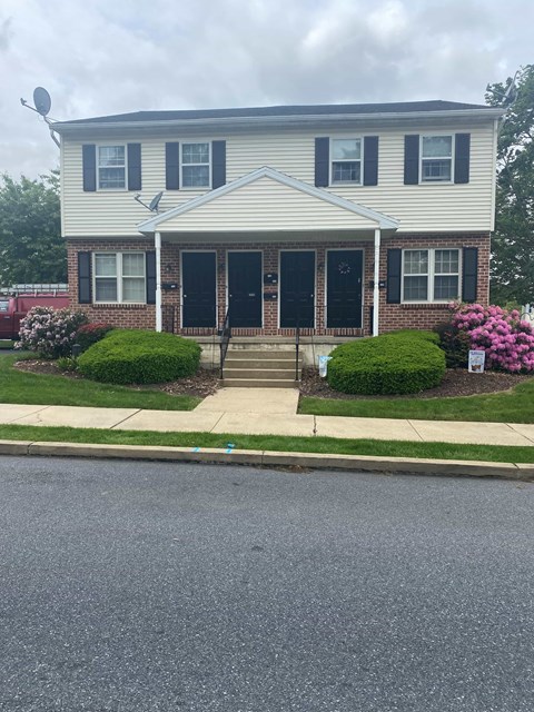 A house with a grey roof and a black door.