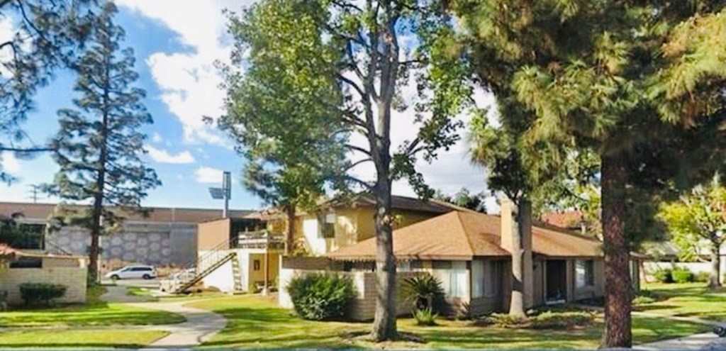 A house with a brown roof and a white car parked in front.