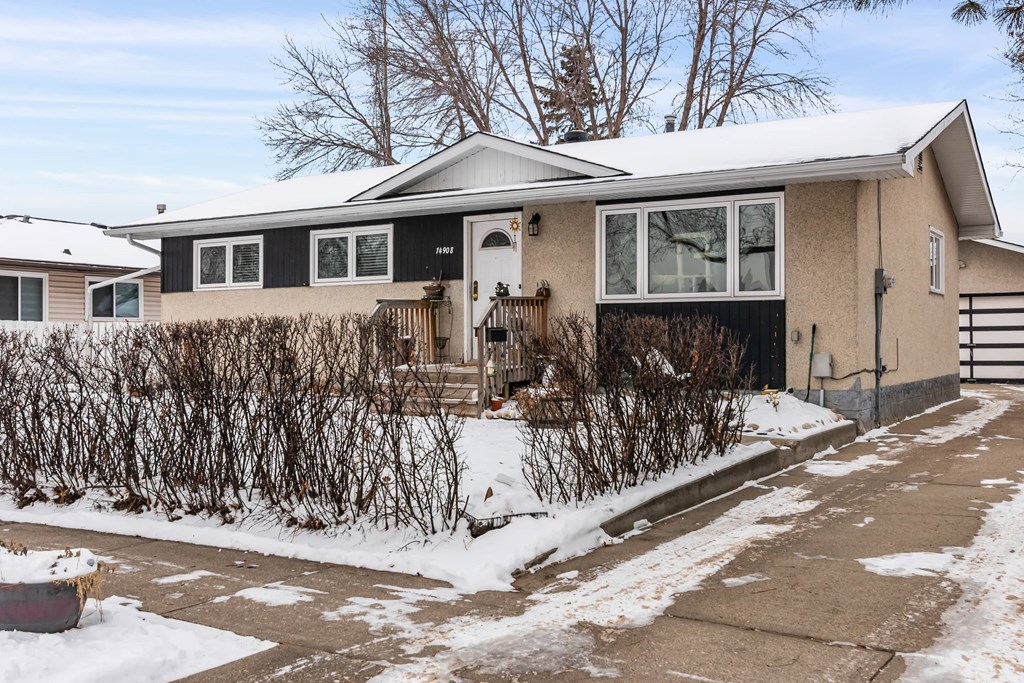 A house with a snow-covered ground in front.
