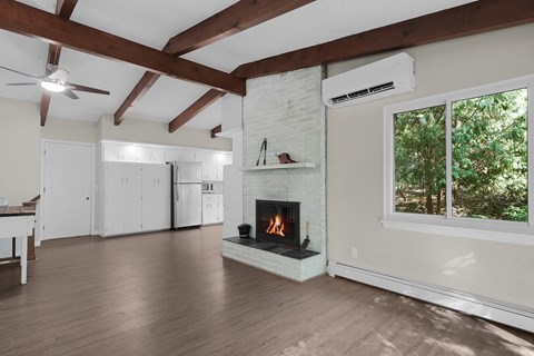 A living room with a fireplace and wood floors.