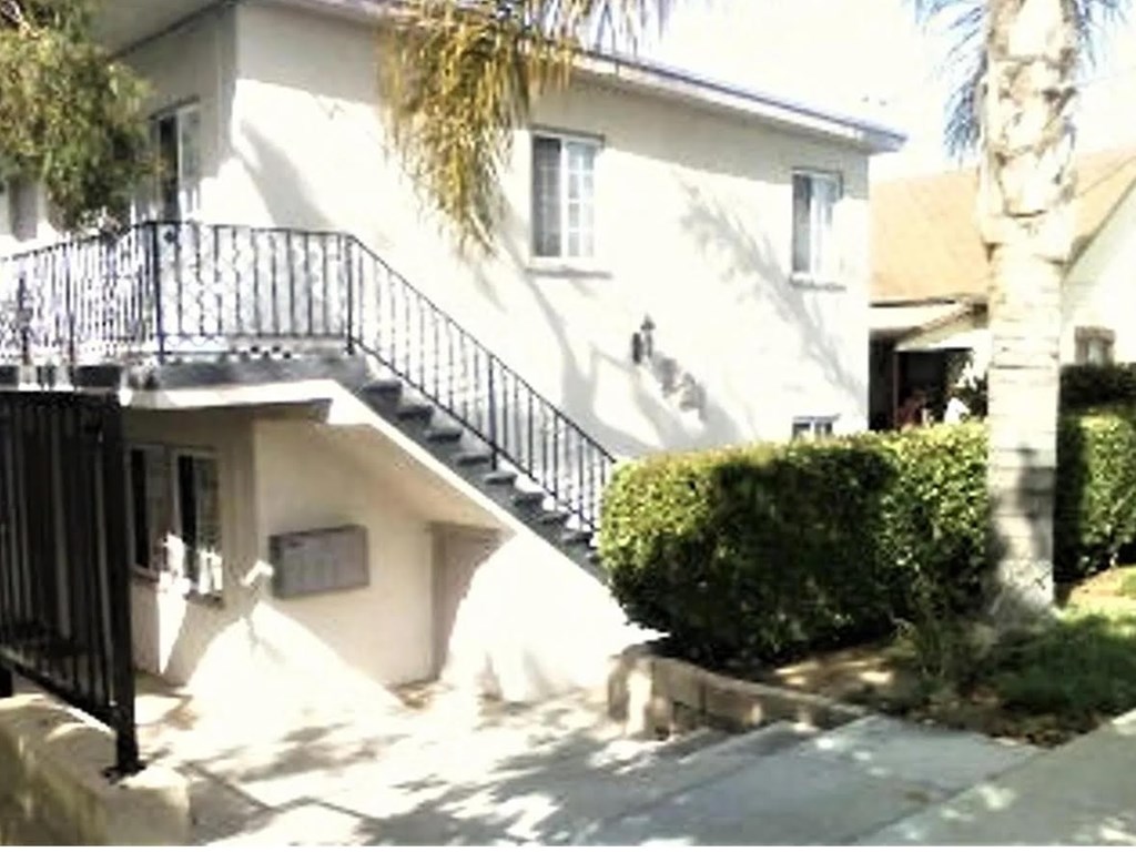 A white house with a black railing staircase.
