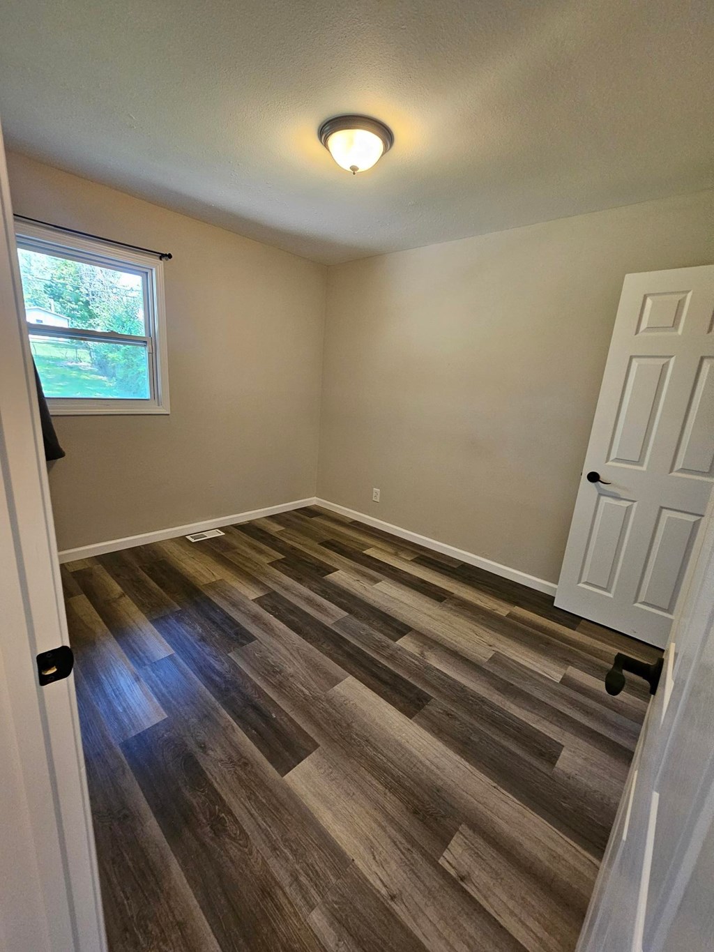 A room with a white door and a window.