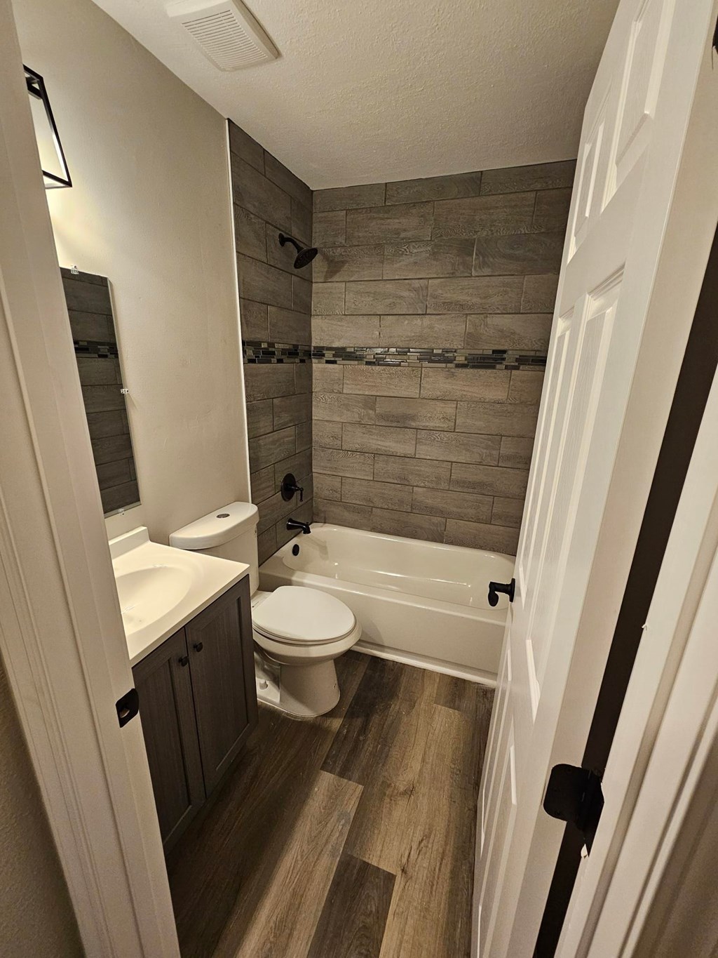 A bathroom with a tub, toilet, and sink.