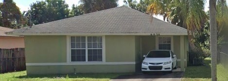 A small house with a car parked in front.
