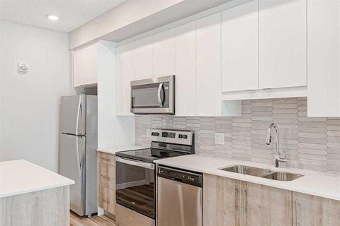 A kitchen with white cabinets and stainless steel appliances.