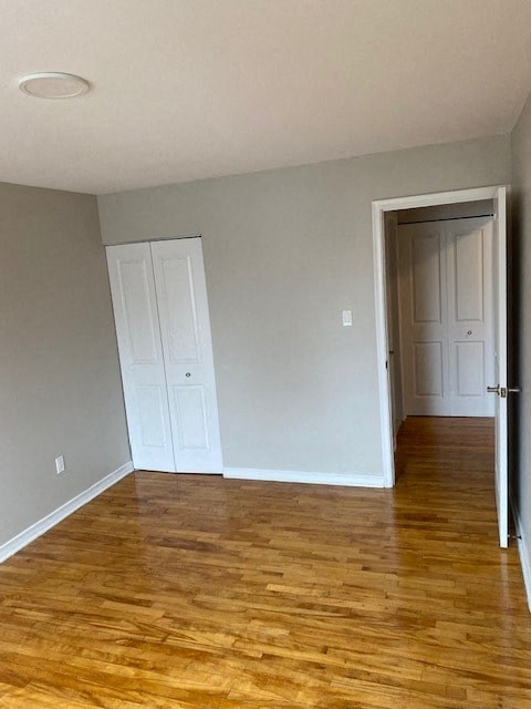 A room with wooden floors and two white doors.