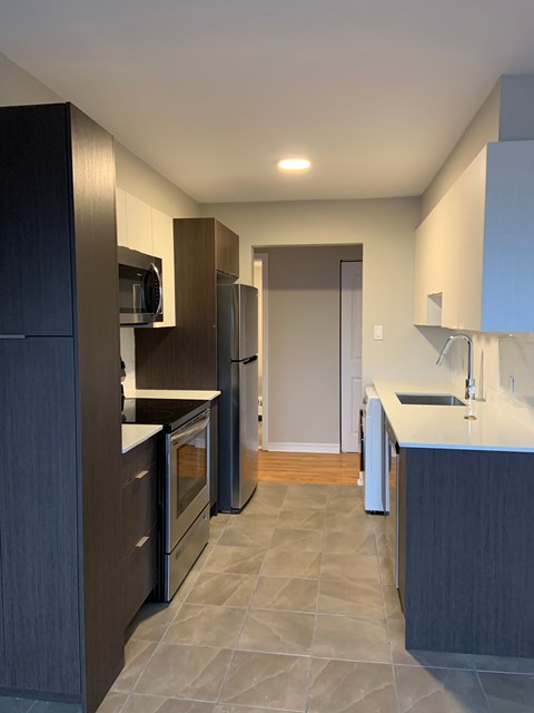 A kitchen with dark wood cabinets and a white counter.