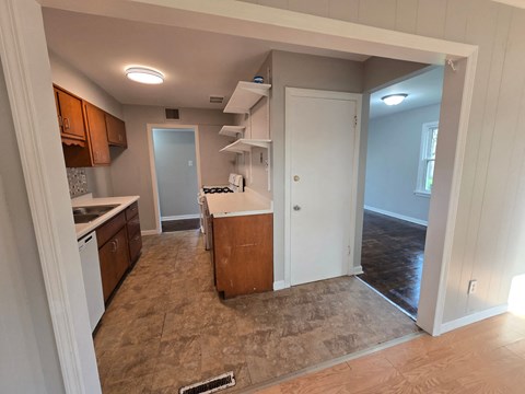 A kitchen with brown cabinets and a white fridge.