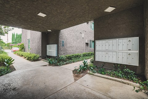 A concrete building with a mailbox and a wall of mailboxes.