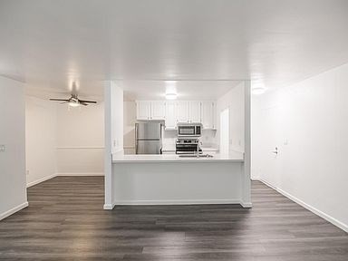 A white kitchen with a fan on the ceiling.
