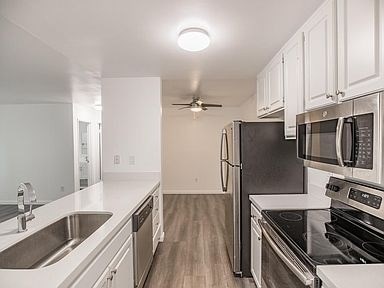 A kitchen with black appliances and white cabinets.