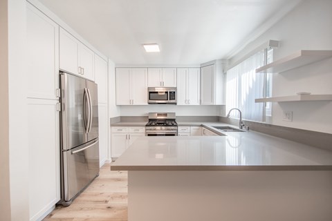 A modern kitchen with a stainless steel refrigerator and a central island.
