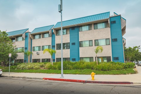 A building with blue and beige panels and a red fire hydrant in front.