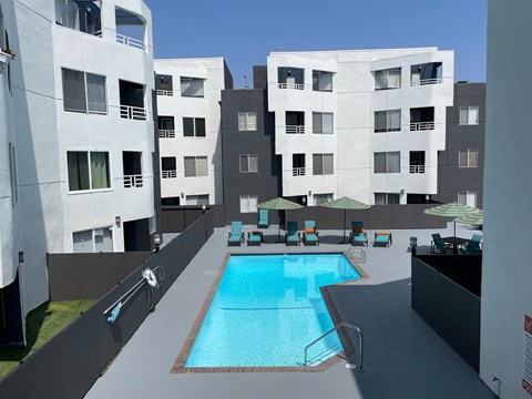 A swimming pool in the middle of a courtyard surrounded by buildings.