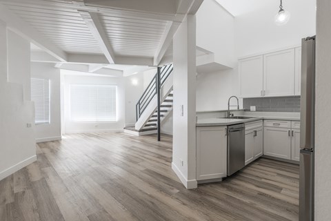 A modern kitchen with a staircase leading to the upper floor.