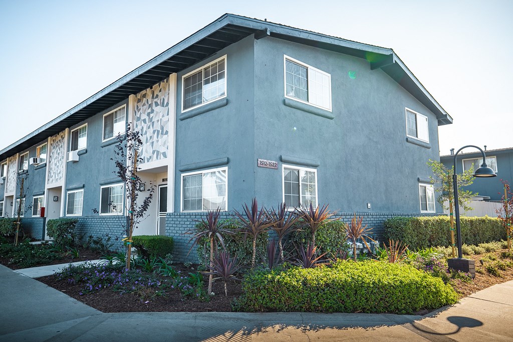 A grey building with a green lawn in front.
