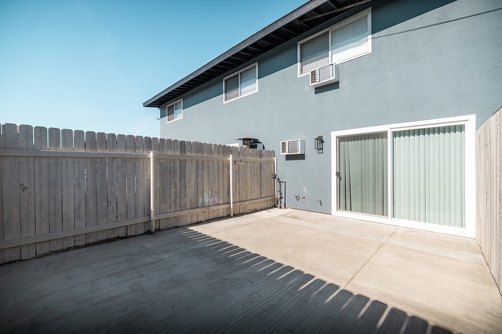 A house with a grey wall and a wooden fence.