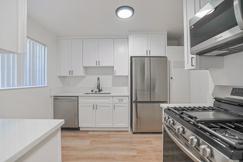 A kitchen with white cabinets and stainless steel appliances.