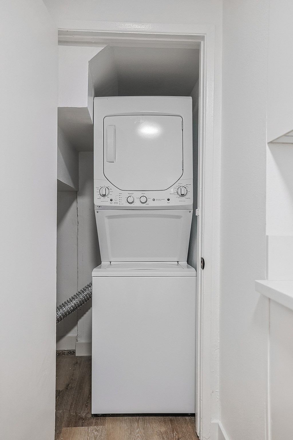 A white oven and microwave are installed in a small kitchen.