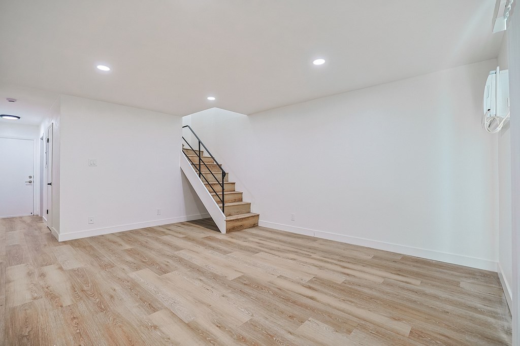 A wooden staircase in a white room.