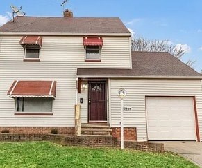 A house with a brown door and a red awning.