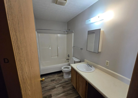 A bathroom with a toilet, sink, and shower.