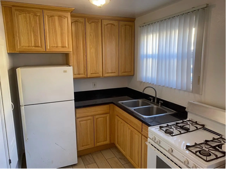 A kitchen with wooden cabinets and a white refrigerator.