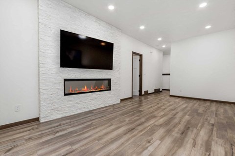 A modern living room with a fireplace and a flat screen TV mounted on the wall.