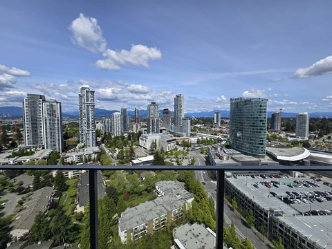 A cityscape with tall buildings and a parking lot.