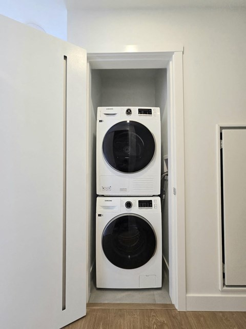 A white washing machine and dryer in a small laundry room.