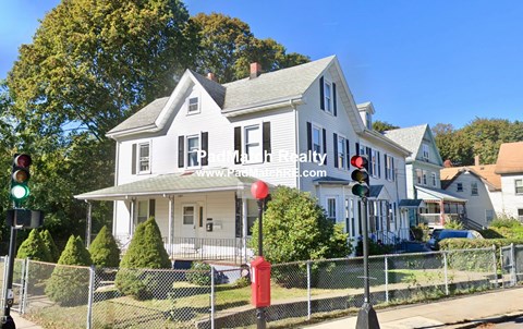 A house with a sign that says "High Rental" in front of it.