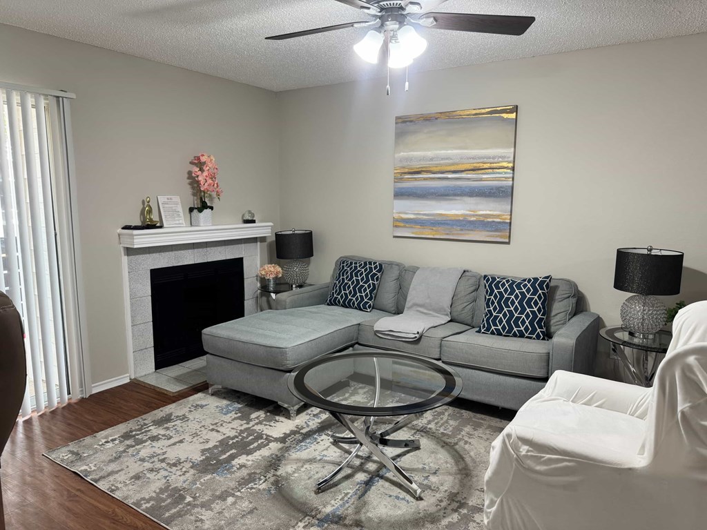 A living room with a grey couch, a coffee table, and a fireplace.