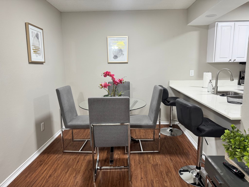 A kitchen with a table and chairs.