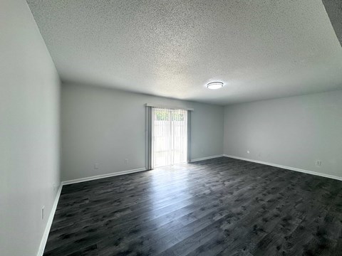 A room with a slanted ceiling and a doorway leading to a balcony.