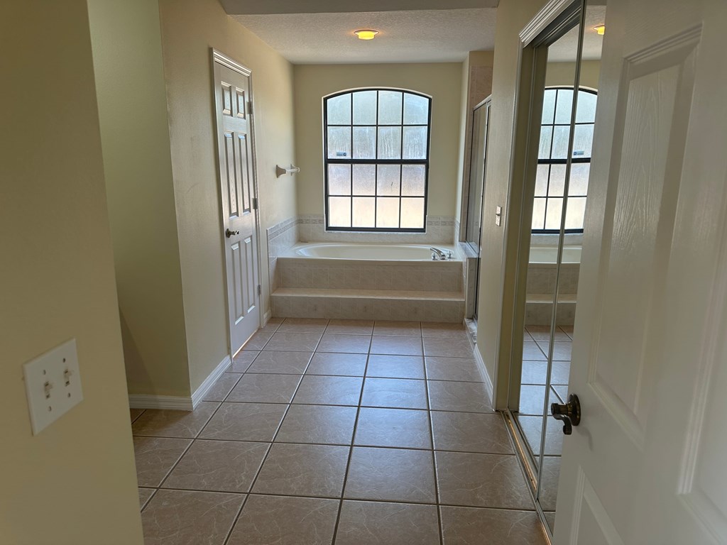 A bathroom with a tub and a window.
