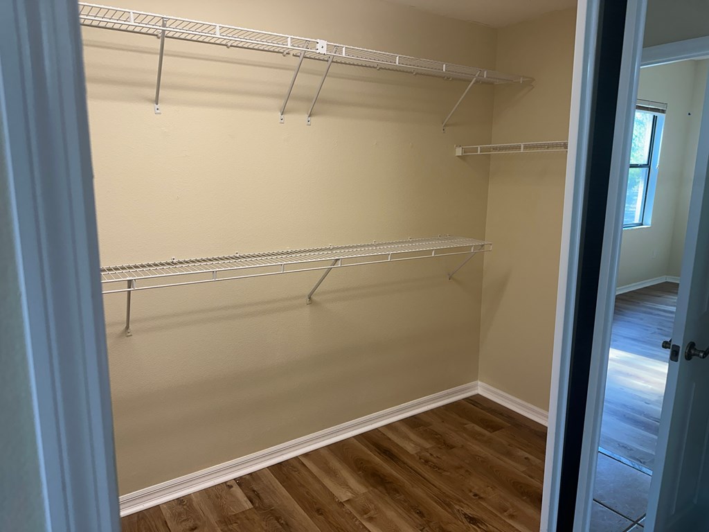 Empty room with white walls and wooden floor.